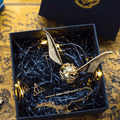 https://cdn.shopify.com/s/files/1/0743/8945/5069/files/puzzloria-3d-metal-puzzle-gold-puzzloria-golden-snitch-ring-box-43347441385693.png?v=1747584044