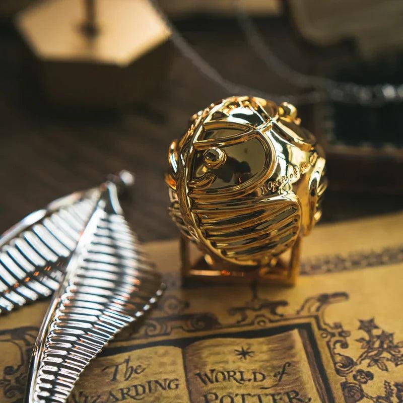 https://cdn.shopify.com/s/files/1/0743/8945/5069/files/puzzloria-3d-metal-puzzle-gold-puzzloria-golden-snitch-ring-box-43347441483997.webp?v=1747754526